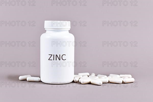 Bottle with Zinc mineral supplement inscription with capsules