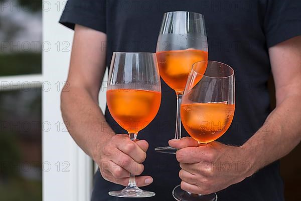 Three glasses of Aperol Spritz are served