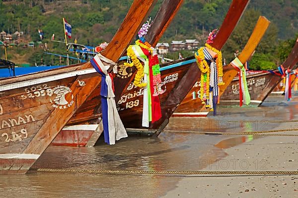 Prows of traditional wooden fishing boats on the beach of one of the Ko Phi Phi islands