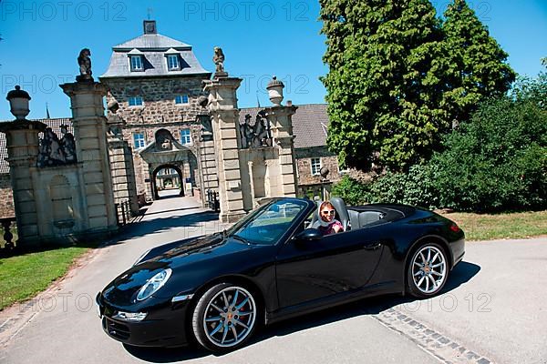 Woman with Porsche 911 cabriolet in front of castle