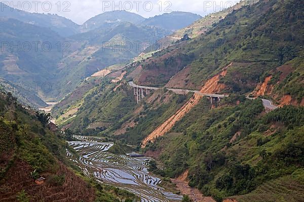 Chinese motorway and terraced rice paddies on the hillside in Yunnan Province