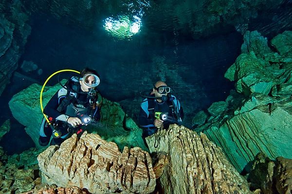 Diver under water in cave entrance of a freshwater cave