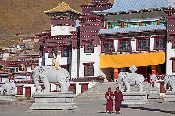 Two monks in front of the Tibetan monastery Sershu Dzong in Sershu village