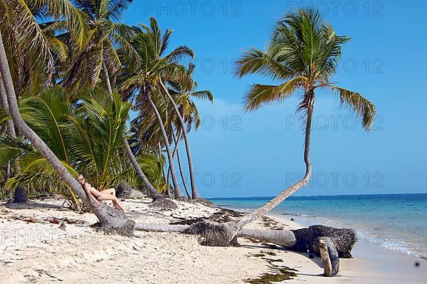 Woman on the beach with palm trees