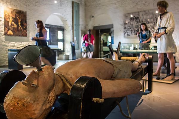 Torture rack and tourists visiting the torture room in the Gravensteen