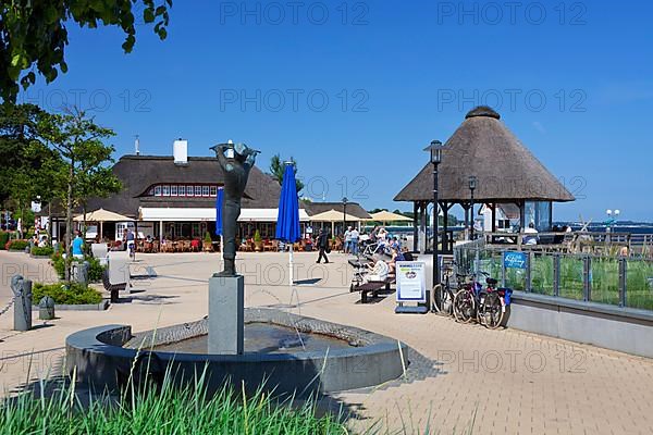 Statue and cafe-restaurant on the promenade in the seaside resort of Haffkrug
