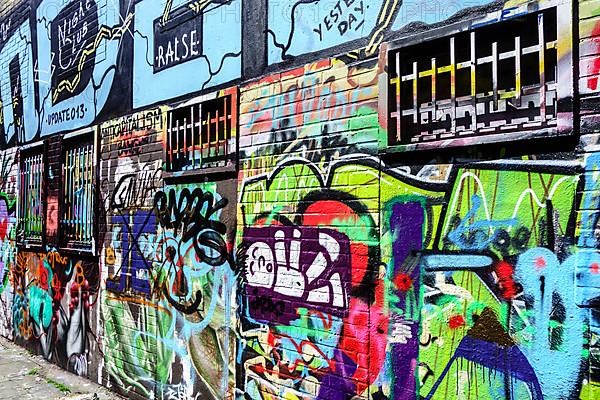 Colourful graffiti on wall in alleyway