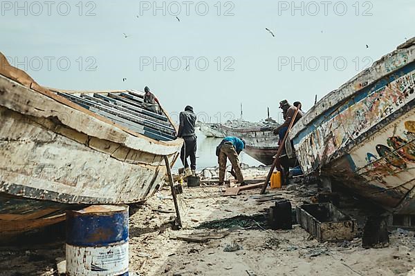 Fishermen repairing a boat