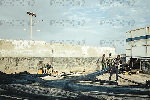 Fishermen repairing nets