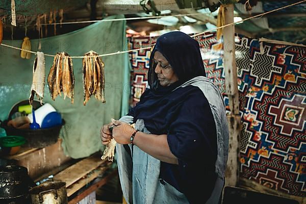 Woman hanging the salted roe in a tent