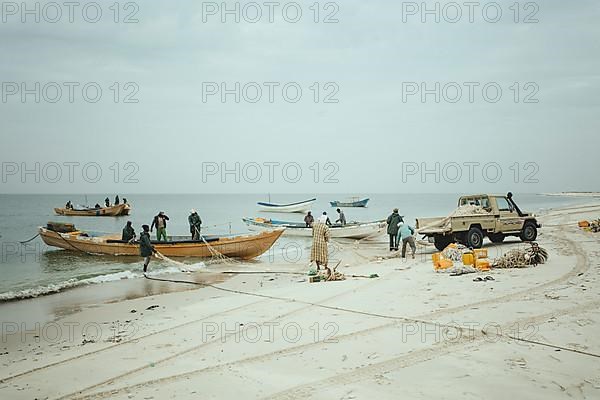 Loading a net onto a fishing boat on the beach