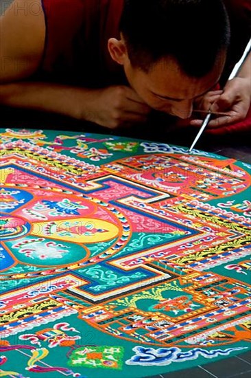 Tibetan monk making a temporary sand mandala in San Diego