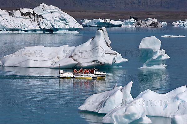 Tourists in an amphibious vehicle among icebergs in the Joekulsarlon glacier lagoon