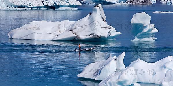 Rubber dinghy in front of icebergs in Joekulsarlon glacier lagoon