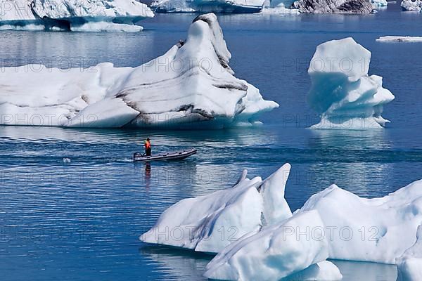 Rubber dinghy in front of icebergs in Joekulsarlon glacier lagoon