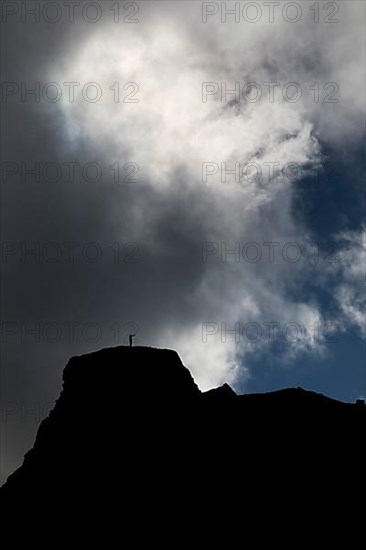 Dramatic sky with two people in front of clouds on a mountain in Kirkjubaejarklaustur