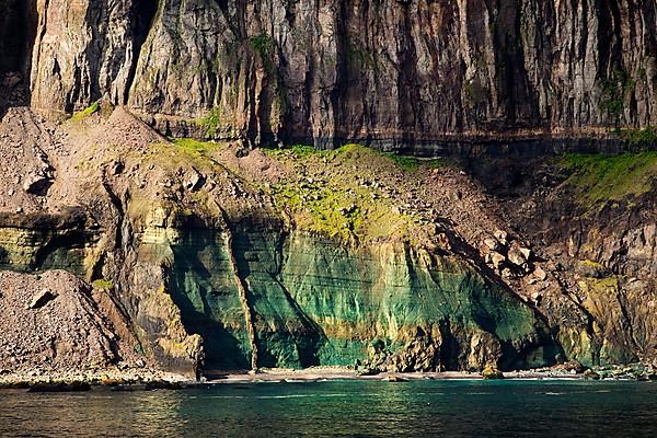 Steep coast with colourful bay at the fjord Seydisfjoerdur