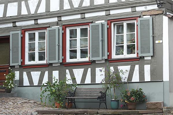 Half-timbered house with three shutters and bench in Schlossbergstrasse