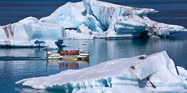 Tourists in an amphibious vehicle among icebergs