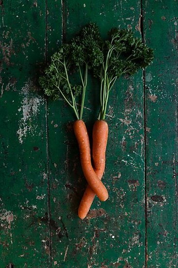 Two carrots bent into each other with parsley