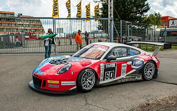 Race car Porsche 911 991 GT3 R sees green flag for exit on race track