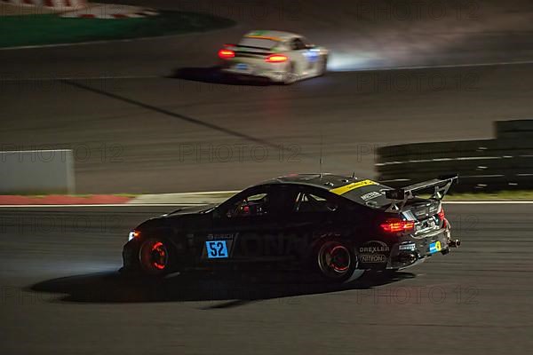 Race car BMW M4 at night during car race 24-hour race 24h race on Grand Prix track of Nuerburgring race track with glowing brake discs