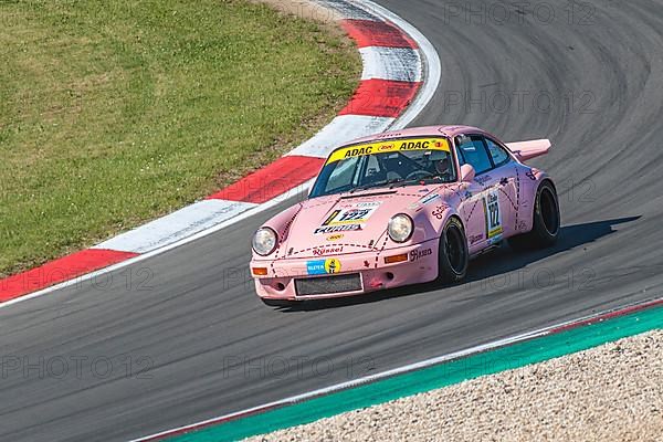 Historic racing car Porsche 911 Carrera RS with historic design paint Sau at car racing for oldtimer youngtimer classic cars 24-hour race 24h race