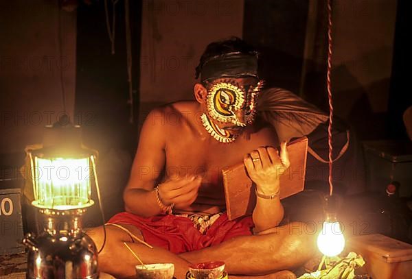 Actor begins to apply the special makeup used in Kathakali