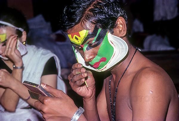 A Katakali artist applying makeup