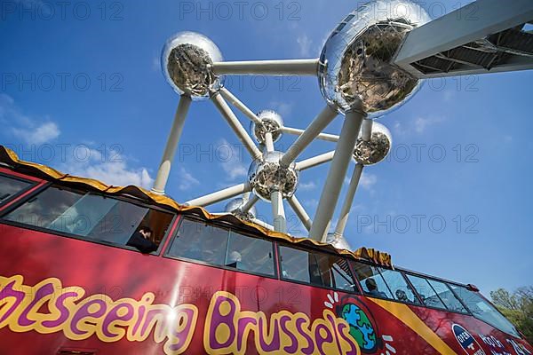 Red bus from City Sightseeing Brussels drives under the Atomium