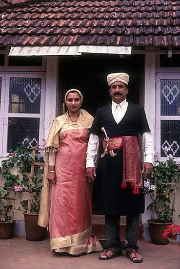 Kodava couple in traditional house in front of their house