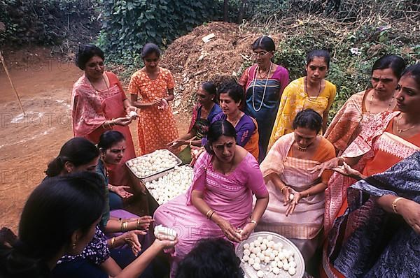 Kodava women making rice ball Kadamputtu during Huthri festival