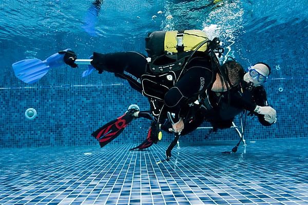 Disabled diver with prosthetic legs and diving instructor