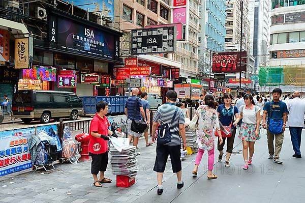 Woman handing out newspapers to passers-by