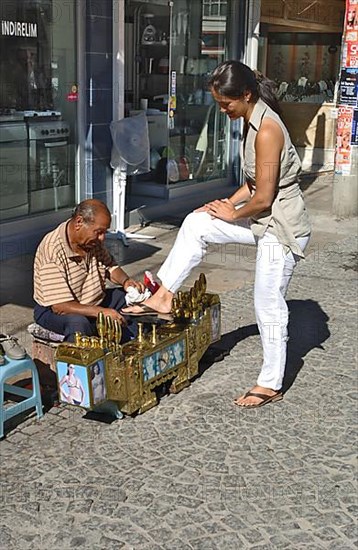 Shoeshine boy with customers