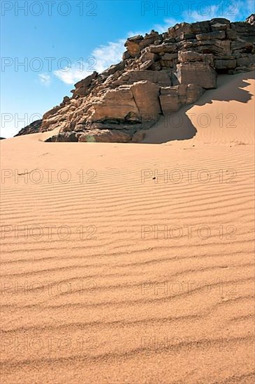 Dunes and rock formation in sand desert
