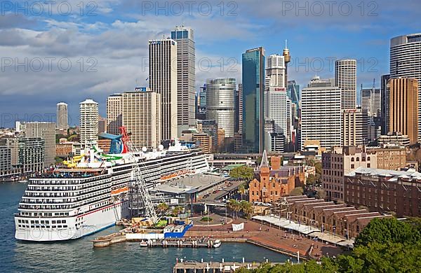 Cruise ship Carnival Spirit docked in Sydney Harbour overlooking the city centre with its colonial buildings and modern skyscrapers
