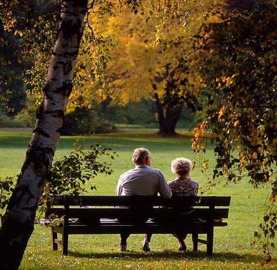 Old couple on the park bench autumn mood