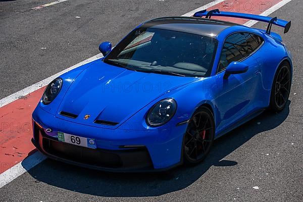 Blue sports car race car Porsche 911 992 GT3 in pit lane pit lane of race track