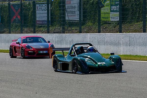 Radical SR10 open-wheel racing car in front behind Porsche Cayman GT4 races at high speed top speed during trackday on start-finish straight of race track