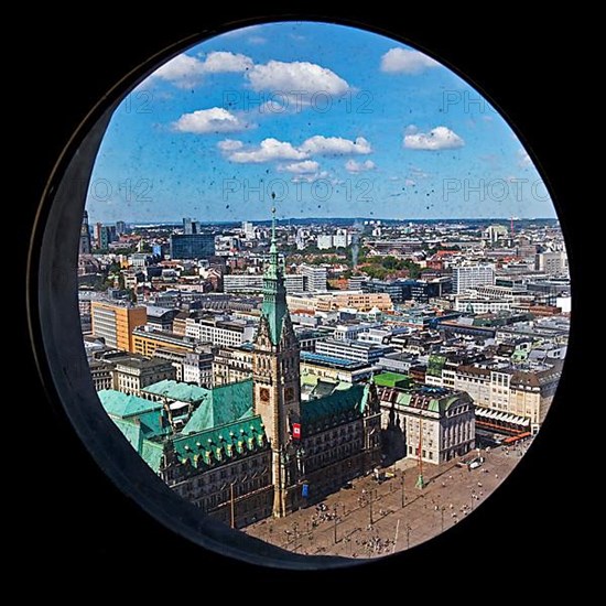 City view with the town hall through the porthole windows in the spire of the main church of St. Petri