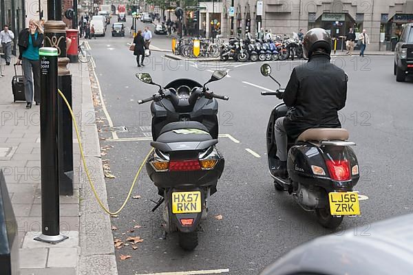 Motorist waiting to recharge his scooter