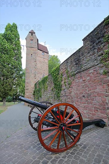 Cannon with wagon wheels in front of the historic town wall and powder tower as landmark of Eberbach
