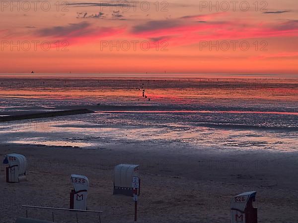 Beach chairs in the late evening on the beach of Cuxhaven with a view of the Elbe estuary