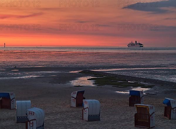 Beach chairs in the late evening on the beach of Cuxhaven with a view of the Elbe estuary