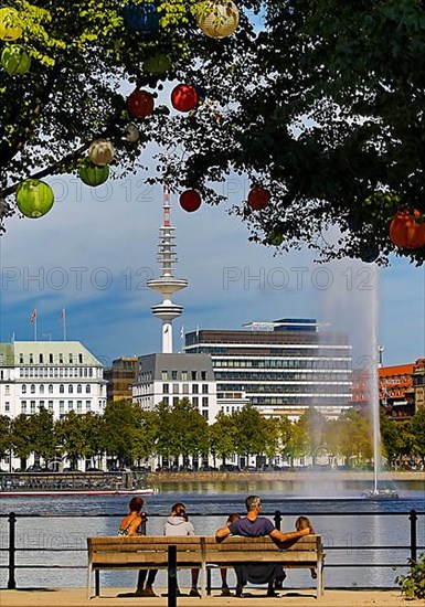 The trees on Ballindamm by the Inner Alster Lake are decorated with lanterns at Hamburg's summer gardens