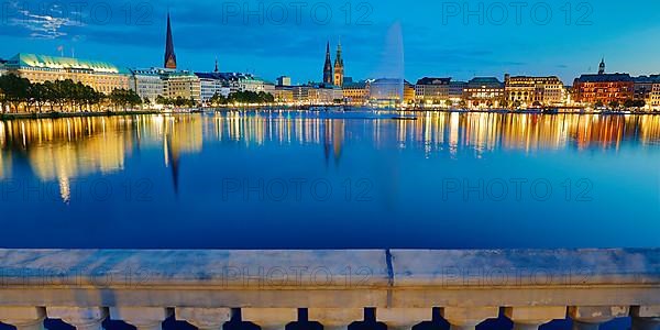 Inner Alster with Alsterfontaine and city skyline in the evening