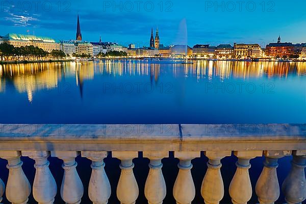 Inner Alster with Alsterfontaine and city skyline in the evening