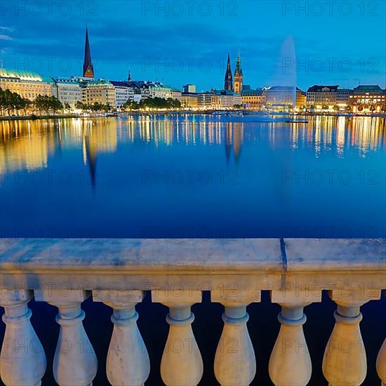 Inner Alster with Alsterfontaine and city skyline in the evening