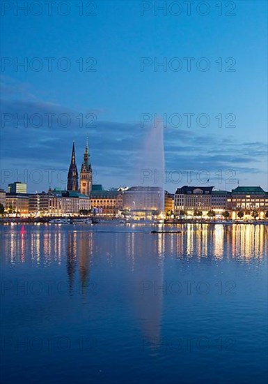 Inner Alster with Alsterfontaine and city skyline in the evening